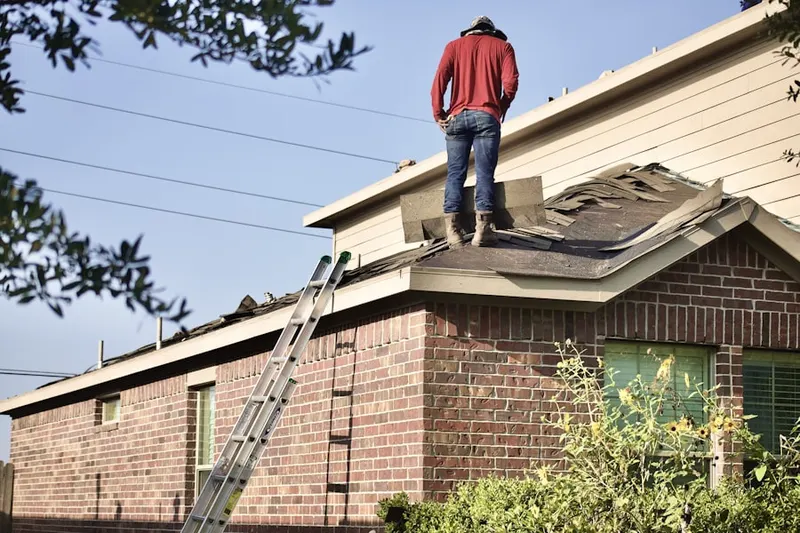 Professional roofer working on a residential roof in Mystic